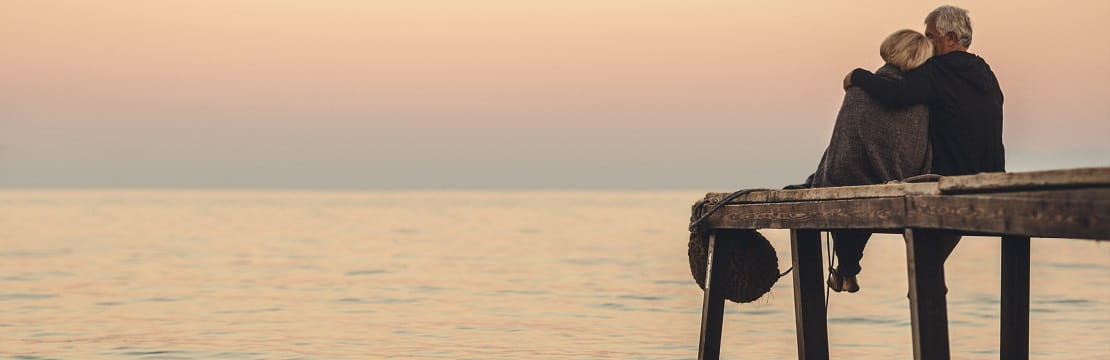 Couple sitting on dock watching the sunset